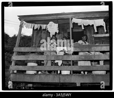 Mrs. Lawson Mayo und ihre Kinder auf der Veranda ihres Vierzimmerhauses in Mullens, West Virginia, wo sie 6,50 Dollar monatlich mieten. Das Haus hat keine grundlegenden Annehmlichkeiten wie fließendes Wasser und ist seit Jahren ohne Reparaturen. Stockfoto