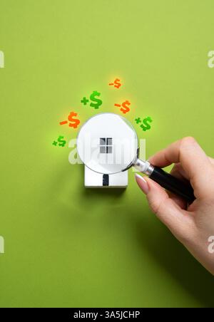 Ein Haus unter einer Lupe studieren. Immobilienbewertung vor dem Kauf. Was bringt Gewinn und was erfordert Kosten für Reparaturen und A Stockfoto