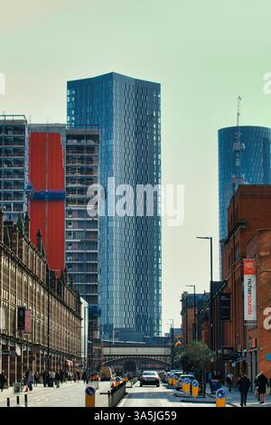 Blick auf Stadtgebäude und Fußgänger, mit Schwerpunkt auf modernen Wolkenkratzern und roter Backsteinarchitektur in Manchester, Großbritannien. Stockfoto