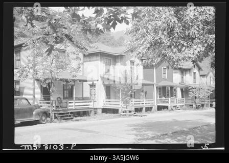 Die Vorderansicht eines Stuckhauses in Upper Omar, Logan County, Virginia, mit einer Frau auf der Veranda, Teil des West Virginia Coal & Coke Corp. Wohnungsprojekts. Stockfoto