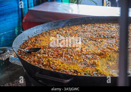 Große Pfanne mit farbenfroher traditioneller Meeresfrüchtepaella mit frischen Zutaten Stockfoto