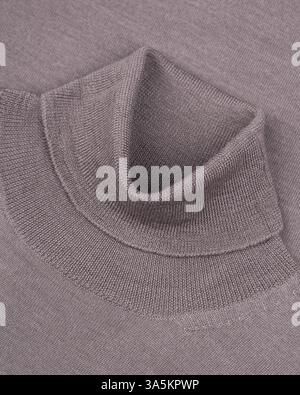 Ein Rundhalsausschnitt auf einem Taupe-Pullover aus Wolle zeigt die weiche Textur, das hochwertige Strickmaterial und das elegante Design dieses hochwertigen Kleidungsstücks Stockfoto