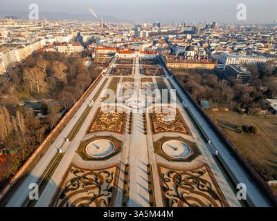 22.02.2025, Wien, Luftaufnahme der atemberaubenden Gärten des Belvedere mit formellen Grundrissen und lebendigen Blumenbeeten, vor einem malerischen Wien Stockfoto