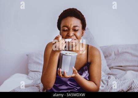 Zerfall Konzept. Weinendes Mädchen, das Eis im Bett isst Stockfoto