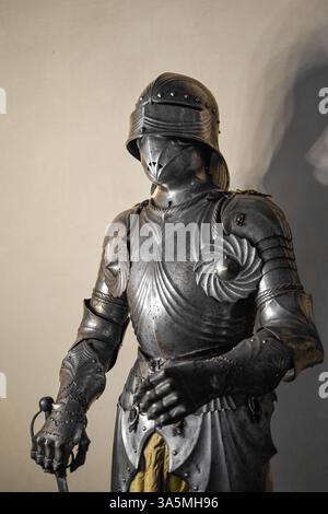 Vorderansicht der mittelalterlichen glänzenden Rüstung mit Details und weißer Wand im Hintergrund Stockfoto