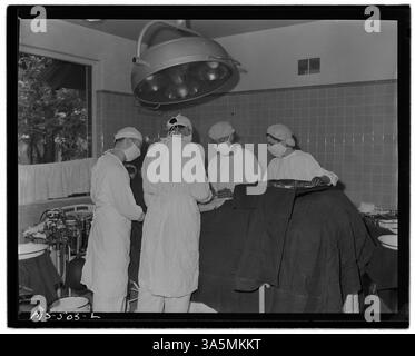 Ärzte führen eine Operation in einem firmeneigenen Krankenhaus durch, das von der Colorado Fuel & Iron Company in Pueblo, Colorado betrieben wird, und spiegeln die Rolle des Gesundheitswesens für Bergleute wider. Stockfoto