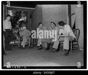 Bergleute, die in einem Hotel in der Castle Gate Mine der Utah Fuel Company in Carbon County, Utah, wohnen, unterhalten sich auf der Veranda und veranschaulichen den sozialen Aspekt des Lebens in Bergbaustädten. Stockfoto
