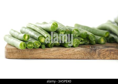 Frisch geschnittene grüne Bohnen werden ordentlich auf einem rustikalen Holzschneidebrett angeordnet, um eine lebendige Präsentation von gesundem, bereit zum Kochen von Gemüse zu schaffen Stockfoto