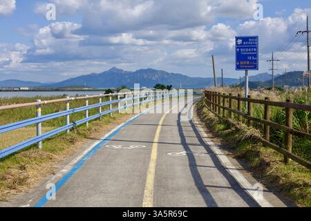 Muan County, Südkorea – 25. September 2020: Ein kurvenreicher Abschnitt des Yeongsangang Bike Path folgt dem Fluss, mit einem blauen Radschild, das die Markierung „DISS“ (deutsch: „Deal“) markiert Stockfoto