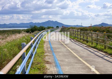 Muan County, Südkorea - 25. September 2020: Ein Abschnitt des Yeongsangang Bike Path folgt dem Flussrand, flankiert von hohen Schilf und Geländern, W Stockfoto