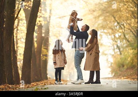 Glückliche Familie von Mutter, Vater und zwei Töchtern sind im Herbst Park, Wald, Straße. Stockfoto