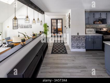 Modernes Haus mit weißen Wänden, Teppichen, Leuchten und Pflanzen Stockfoto