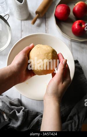 Hausbackkonzept. Weibliche Hände halten rohen Teig für einen Kuchen oder Törtchen Stockfoto
