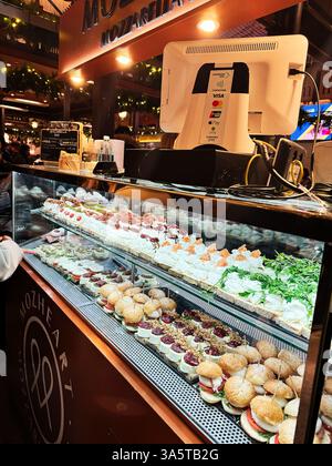Madrid, Spanien - 28. Dezember 2023: Appetitliche kleine Häppchen und Mozzarella-Leckereien auf dem Markt in beleuchteter festlicher Atmosphäre in Madrid, Spanien Stockfoto