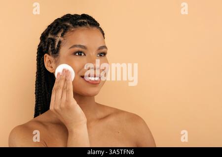 Gesichtsbehandlungen. Happy Black Woman Verwendet Baumwollkissen Zur Gesichtsreinigung Stockfoto