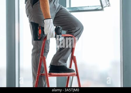 Nahaufnahme des Arbeiters, der den unvollendeten Raum renoviert. Stockfoto