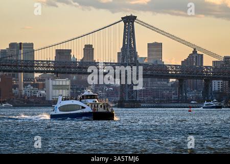 Ein NY Waterway segelt am 22. März 2025 in New York City an der Williamsburg Bridge entlang des East River vorbei. Stockfoto