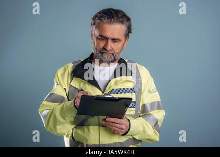 Polizist. Senior Mann steht im Studio vor Hintergrund. Stockfoto