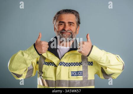 Polizist. Senior Mann steht im Studio vor Hintergrund. Stockfoto