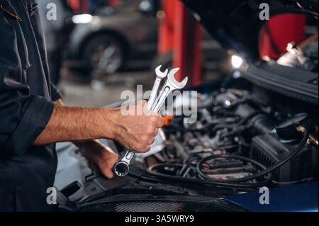 Werkzeuge in der Hand. Nahaufnahme des Mechanikers in der Kfz-Tankstelle. Stockfoto