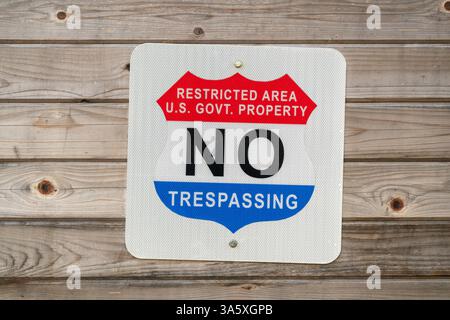 Kein Betreten von Sperrgebieten Warnschild der US-Regierung / USA – Ein standardmäßiges Warnschild der Regierung, das einen Sperrbereich auf US-Regierungseigentum kennzeichnet. Auf dem rot-weißen Schild wird die Meldung „RESTRICTED AREA U.S. GOVT. DAS EIGENTUM IST NICHT ZU BETRETEN, in Fettschrift, dient als offizielle Benachrichtigung, dass unbefugte Einreise verboten ist. Solche Schilder werden häufig an den Grenzen von Bundeseinrichtungen, militärischen Einrichtungen und anderen von der Regierung kontrollierten Gebieten angebracht, um unbefugten Zutritt abzuschrecken. Verstöße gegen das Einschreiten von Bundesbehörden können erhebliche strafrechtliche Konsequenzen nach sich ziehen Stockfoto