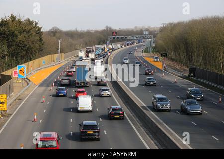 Starker Verkehr auf der M4 Smart Motorway mit Warnschild auf der elektronischen Matrix vor der Baustelle mit Geschwindigkeitsbegrenzung, England Stockfoto