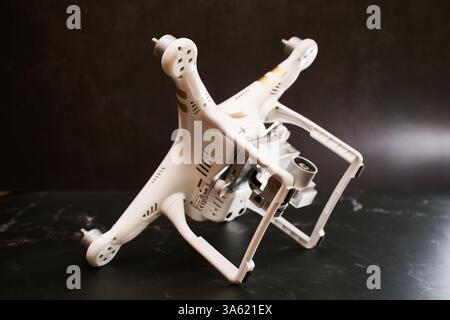 USA, Arizona - 10. März 2025: Weiße Drohne ohne Propeller DJI Phantom 3 liegt auf der Seite auf Ständen auf einem schwarzen Tisch Stockfoto