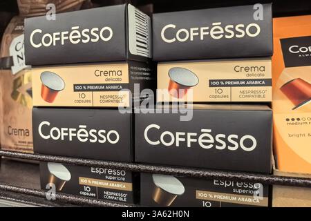 Bobruisk, Weißrussland - 9. März 2025: Farbenfrohe Kartons mit Premium-Kaffeekapseln sind ordentlich in einem Supermarktregal angeordnet. Stockfoto