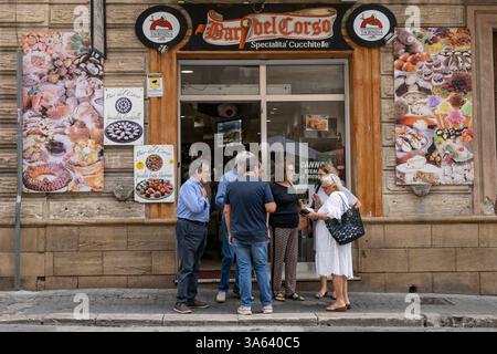 Eine Gruppe von Menschen versammelte sich vor einem Ladeneingang in Sciacca, einer Stadt und Gemeinde in der Provinz Agrigento an der Südwestküste von Stockfoto