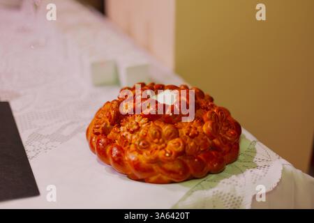 Ein wunderschönes Brot mit Salz bei der Hochzeitszeremonie steht auf dem Tisch und wartet auf das Brautpaar Stockfoto