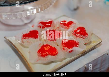Kuchen in Herzform liegen auf einem Teller auf einem festlichen Tisch Stockfoto