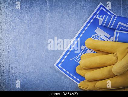 Zusammensetzung der blau gerollten Bauzeichnungen der Sicherheitshandschuhe Stockfoto