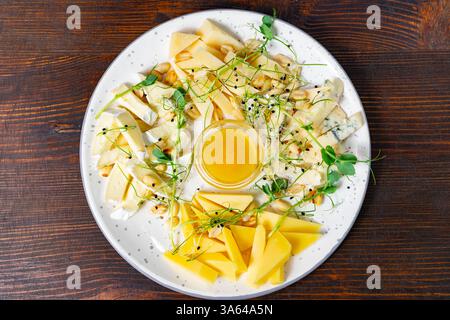 Eine runde Platte bietet eine Auswahl an handwerklich hergestellten Käsesorten, darunter cremige Optionen und scharfe Sorten. Stockfoto