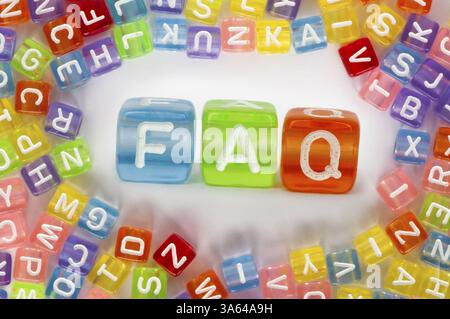 Text FAQ auf bunten Würfel über weiß. Buchstaben weiß zufällig verstreut Stockfoto
