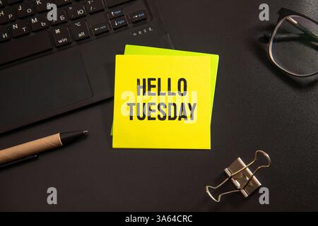 „Hello Tuesday“-Textnachricht mit Blumendekoration auf Holzhintergrund Stockfoto