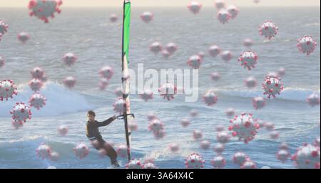 Bild von Zellen, die über dem kaukasischen Mann im Windsurfen schweben Stockfoto