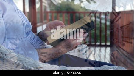 Ältere Person, die Bücher auf der Veranda liest, entspannte sich während der Pandemie-Abriegelung Stockfoto