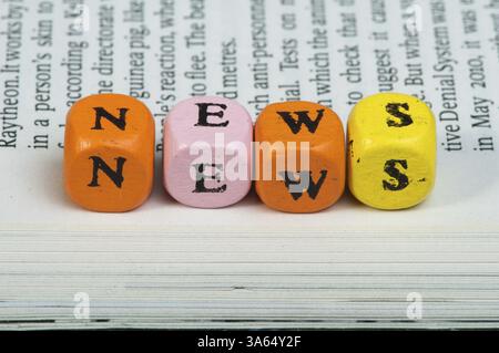 Wort-Nachrichten. Hölzerne Würfel auf Zeitungspapier. Schließen Sie Studio gedreht Stockfoto