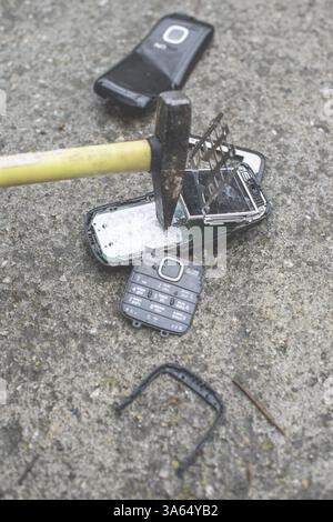 Altes Handy kaputt. Hammer-Falte-Telefon Stockfoto