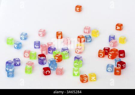 Bunte Würfel mit Buchstaben weiß zufällig verstreut Stockfoto