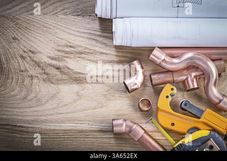 Konstruktionszeichnungen Maßband Wasserrohrschneider-Steckverbinder auf Holzplatte Sanitär-Konzept Stockfoto