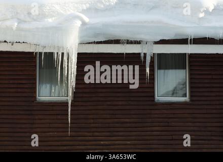 Eiszapfen am Fenster. Holzhaus-windows Stockfoto