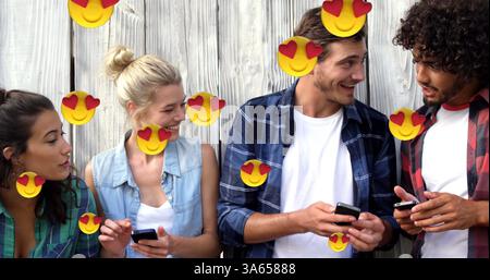 Bild von mehreren Social Media Heart Eyes Gesicht Emoji Symbole mit Menschen, die Smartphones verwenden Stockfoto