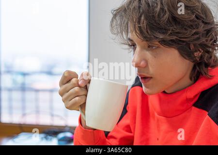 Heiße Schokolade aus einer großen weißen Tasse am Tisch trinken Stockfoto