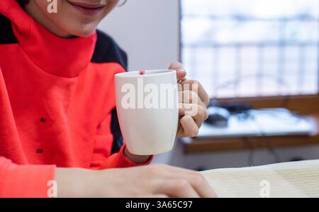 Heiße Schokolade mit Himbeeren aus einer großen weißen Tasse am Tisch trinken Stockfoto