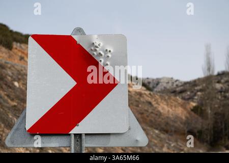 Verkehrsschild mit Einschusslöchern darin. Stockfoto