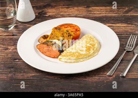 Rustikaler Frühstücksteller mit Spiegeleiern, gegrilltem Gemüse und putenspeck Stockfoto