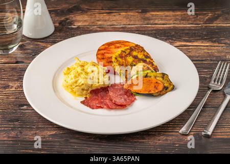 Rustikaler Frühstücksteller mit Spiegeleiern, gegrilltem Gemüse und putenspeck Stockfoto