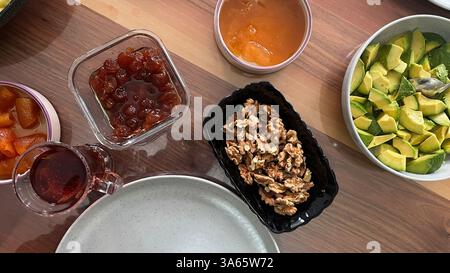 Marmeladen, Chutneys, Avocadoscheiben und Tee am Frühstückstisch. Stockfoto
