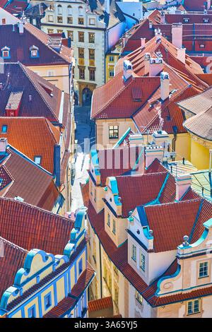 Der Turm des Alten Rathauses überblickt die historischen Stadthäuser von Staromestske namesti und die schmale Melantrichova-Straße, die zwischen den Häusern verläuft. Stockfoto